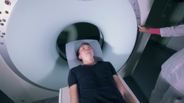 Пациентка входит в механизм МРТ под наблюдением женщин-врачей — стоковое видео