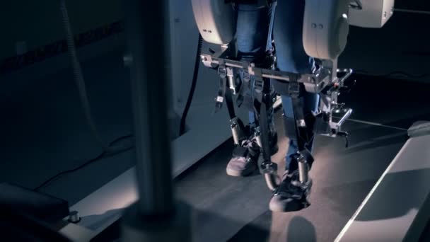 Slow motion beelden van de benen van een fysiek uitgedaagd man lopen in een simulator — Stockvideo