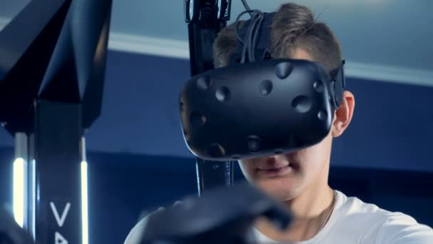 En ung man är klädd i virtuell verklighet headset och spela 360 virtuell verklighet spel. — Stockvideo