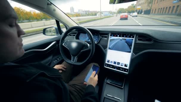 L'homme est assis dans une voiture électrique en plein pilote automatique. Futuriste voiture électrique automatisée auto-conduite . — Video