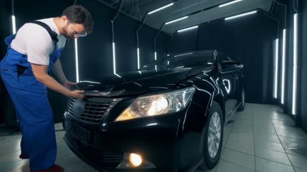 Mécanicien vient à une voiture et ouvre son capot — Video