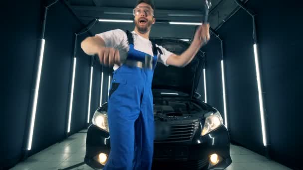 Serviceman is dancing near an automobile with instruments in his hands — Stock Video