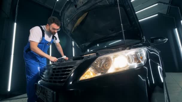 Reparatie werken worden op een auto vastgehouden door een technicus — Stockvideo