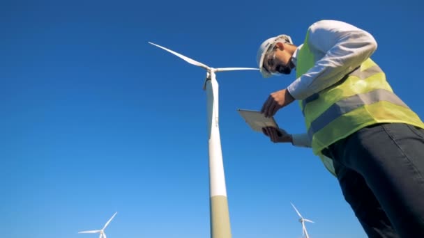 Les éoliennes sont observées par un expert masculin. Concept énergétique propre et respectueux de l'environnement . — Video
