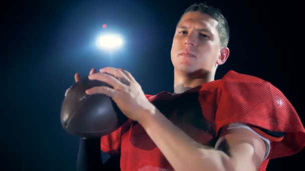 Un footballeur américain déterminé tourne le ballon dans ses mains — Video