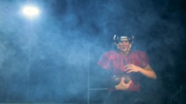 Amerikan futbolu atlet bir top ile çalışan ve kameraya doğru işaret