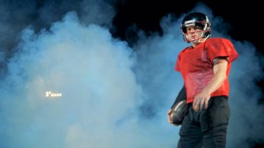 Duman ve üzerinde duran bir Amerikan futbolu sporcu ile Kapalı Stadyumu