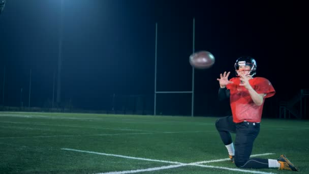 アメリカン フットボールのボールは追い出されている地面とプレーヤーの手の間から — ストック動画