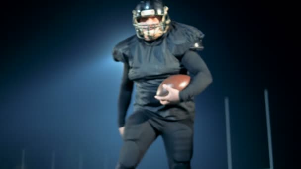 Competitive American football athlete stops and points into the camera — Stock Video