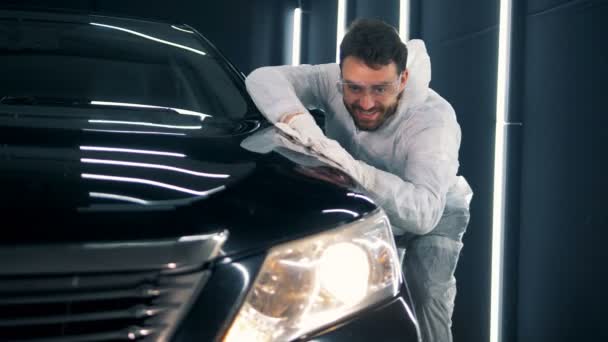 Un tecnico entusiasta sta pulendo un'auto con un panno — Video Stock