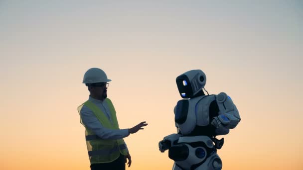 Ingénieur regarde un robot travailler, gros plan . — Video