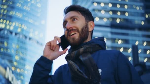 Mladý muž mluvil po telefonu a usmívá se. Epické kino kamera natáčela. — Stock video