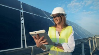 Enerji mühendisi onun bilgisayar işletim ve bir gülümseme ile güneş pili yanında ayakta