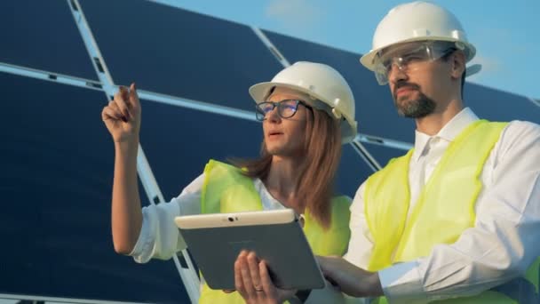Egy nő és egy férfi energetikai munkavállalók építési projekt megbeszélése és különböző irányokba mutat — Stock videók