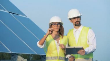 Güneş enerjisi kavramı. Güneş dizi ve iki uzman o ileri bir tartışma yaparken yürüyüş