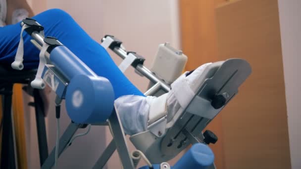 Kişi özel bir makine bir bacak tedavi gören bir sandalyeye oturur. 4k. — Stok video