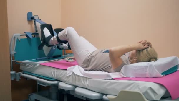 Mulher treinando em um dispositivo médico, visão traseira . — Vídeo de Stock