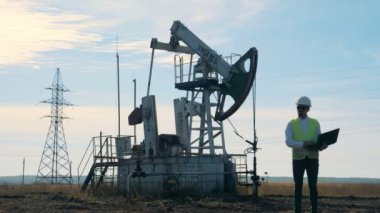 Petrol-derrick ve diz üstü yanında çalışan bir erkek uzmanı