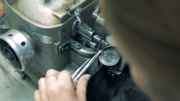 Ένας ράφτης χρησιμοποιεί εργοστάσιο ράβοντας μηχανή, εσωτερικη. — Αρχείο Βίντεο