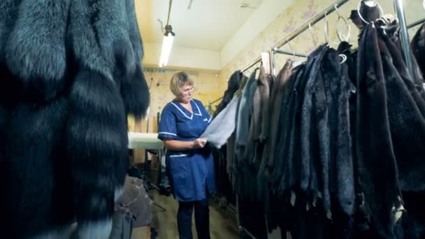 Ein Arbeiter betrachtet hängende Tierfelle aus nächster Nähe. — Stockvideo