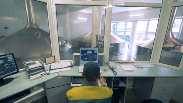 Mannelijke expert is het observeren van werkproces van brouwerij reservoirs via computer — Stockvideo