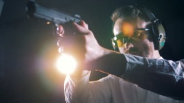 Bir çekim odasında elinde bir tabanca ile ayakta, aralığı çekim adam.