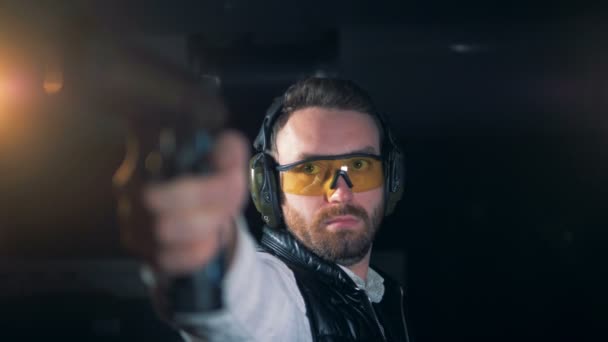 Male shooter aims with a gun in a shooting room, close up. — Stock Video