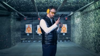 Bir adam bir silah ve bir kamera bakar yakın tutar.