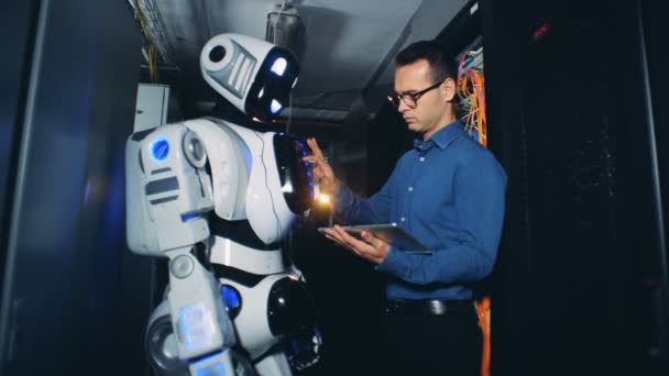 男人在数据中心的机器人上设置程序 — 图库视频影像