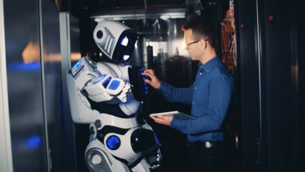 Una persona controla un robot en un centro de datos, de cerca . — Vídeo de stock