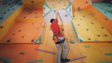 Adam taş bir duvara tırmanmak için tutar..