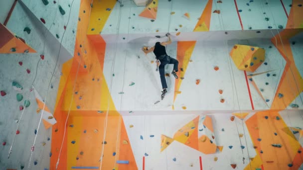 Un hombre entrenando en un muro de escalada . — Vídeo de stock