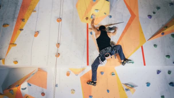 Een persoon op een gevaarlijke klimwand, close-up. — Stockvideo