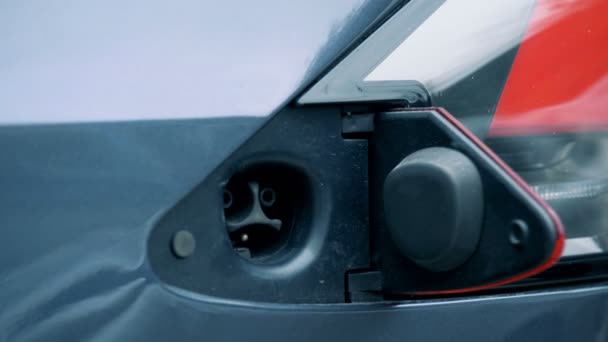 Benzindüse wird in Tankbuchse eines Elektrofahrzeugs gesteckt — Stockvideo