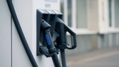 Mavi deşarj meme geri elektrikli bir yeniden yükleme istasyonunda yerine koymak ediliyor