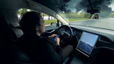 Otomatik bir otomobil içinde oturan sürücüsü ile yol boyunca hareket ediyor