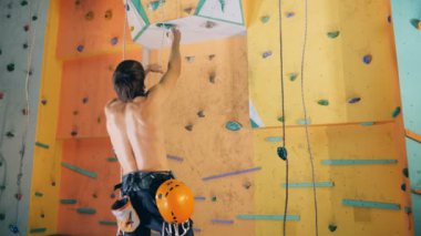 Kişi çalışır kayalara tırmanma duvarı ulaşmak, yakın çekim için.