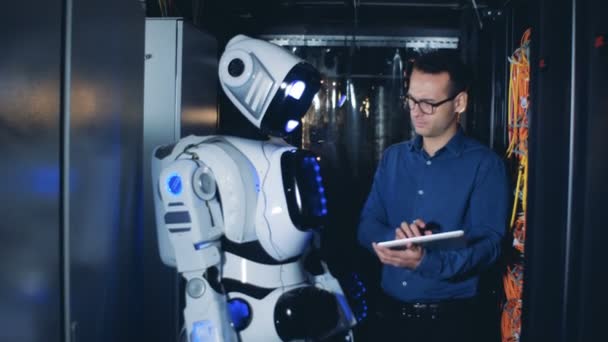 Αρσενικό το προγραμματιστής και ρομπότ, droid εργασία σε ένα κέντρο δεδομένων. — Αρχείο Βίντεο