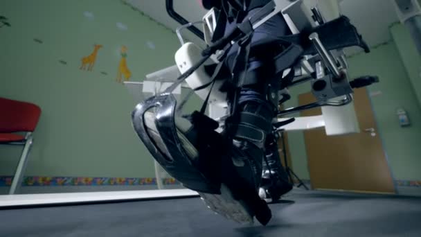 Gros plan des jambes de marche attachées avec les ceintures d'une machine à simuler — Video