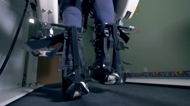 Nahaufnahme fixierter Beine beim Gehen entlang der Simulationsmaschine — Stockvideo