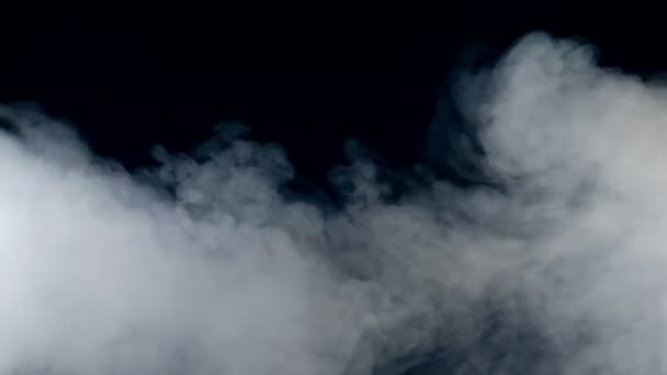 Las ráfagas de humo se están propagando rápidamente. Niebla, humo, nube aislada sobre un fondo negro . — Vídeos de Stock