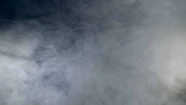 Gruesos volúmenes de humo fluyendo en la oscuridad. Niebla, humo, nube aislada sobre un fondo negro . — Vídeo de stock