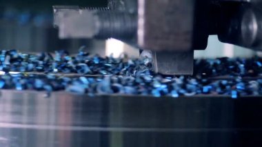 Metal işleme eylem. Bir makine bir çizgi üzerinde metal bir detay keser, yakın çekim.