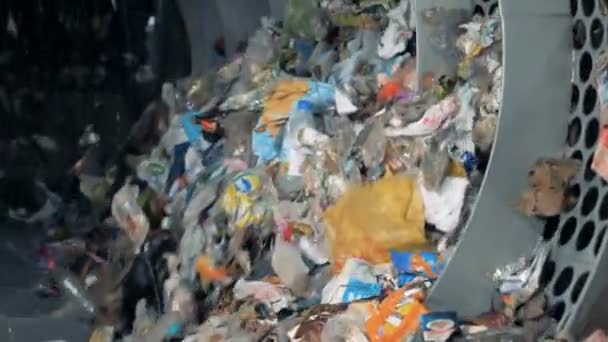 Smistamento rifiuti per il riciclaggio e lo smaltimento. La spazzatura di plastica ruota in una macchina in una fabbrica durante lo smistamento . — Video Stock