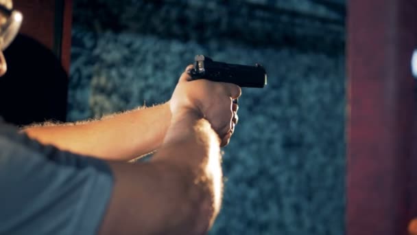 Een man in een galerie afvuren is van een pistool schieten — Stockvideo