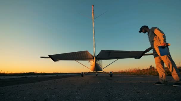 Vlieger controleert een vleugel van de staart van een vliegtuig voordat het opstijgen. — Stockvideo