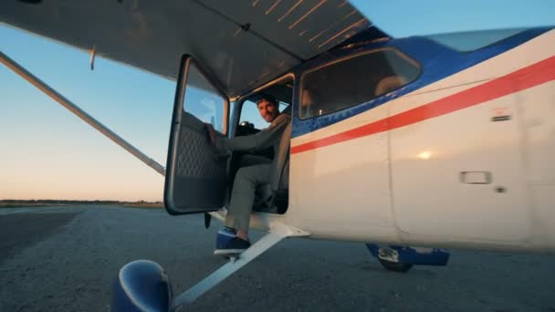 Pilot sitter i en cockpit i ett plan, leende på en kamera. — Stockvideo