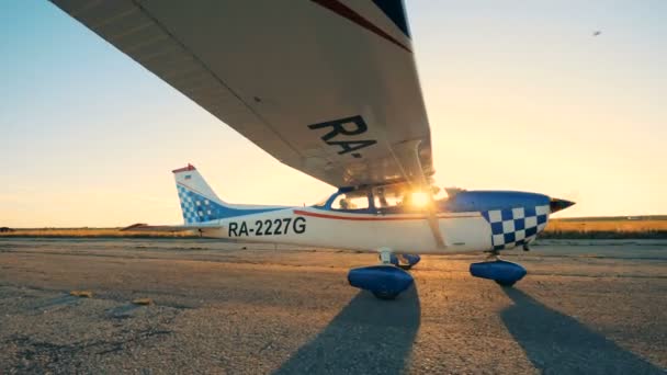 Um avião em movimento sobre um fundo do pôr do sol, vista lateral . — Vídeo de Stock