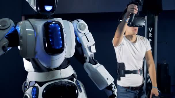L'homme contrôle un robot, en utilisant un équipement VR, gros plan . — Video