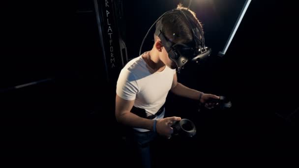 Игрок мужского пола носит виртуальное оборудование во время игры. Роботизированная система виртуальных игр . — стоковое видео